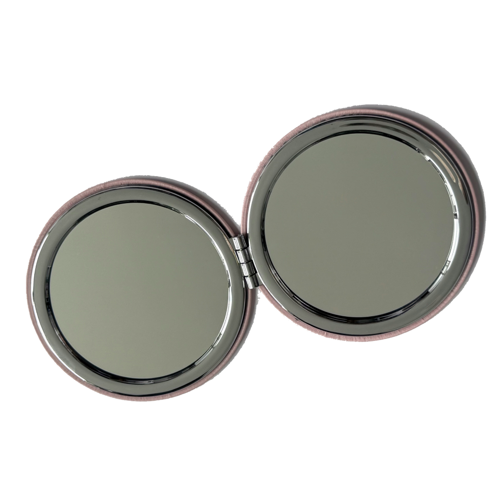 Compact mirror with two round reflective surfaces on a white background