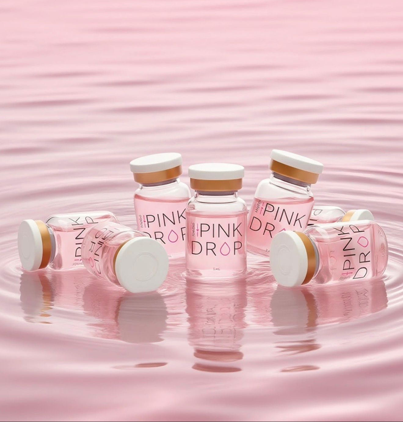 Pink bottles labeled 'Pink Drop' on a pink water background