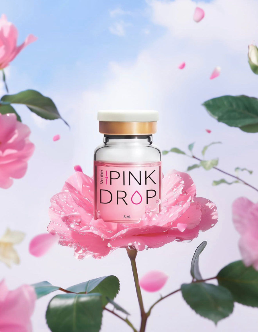 Pink bottle labeled 'The Pink Drop' on a pink flower with a floral background