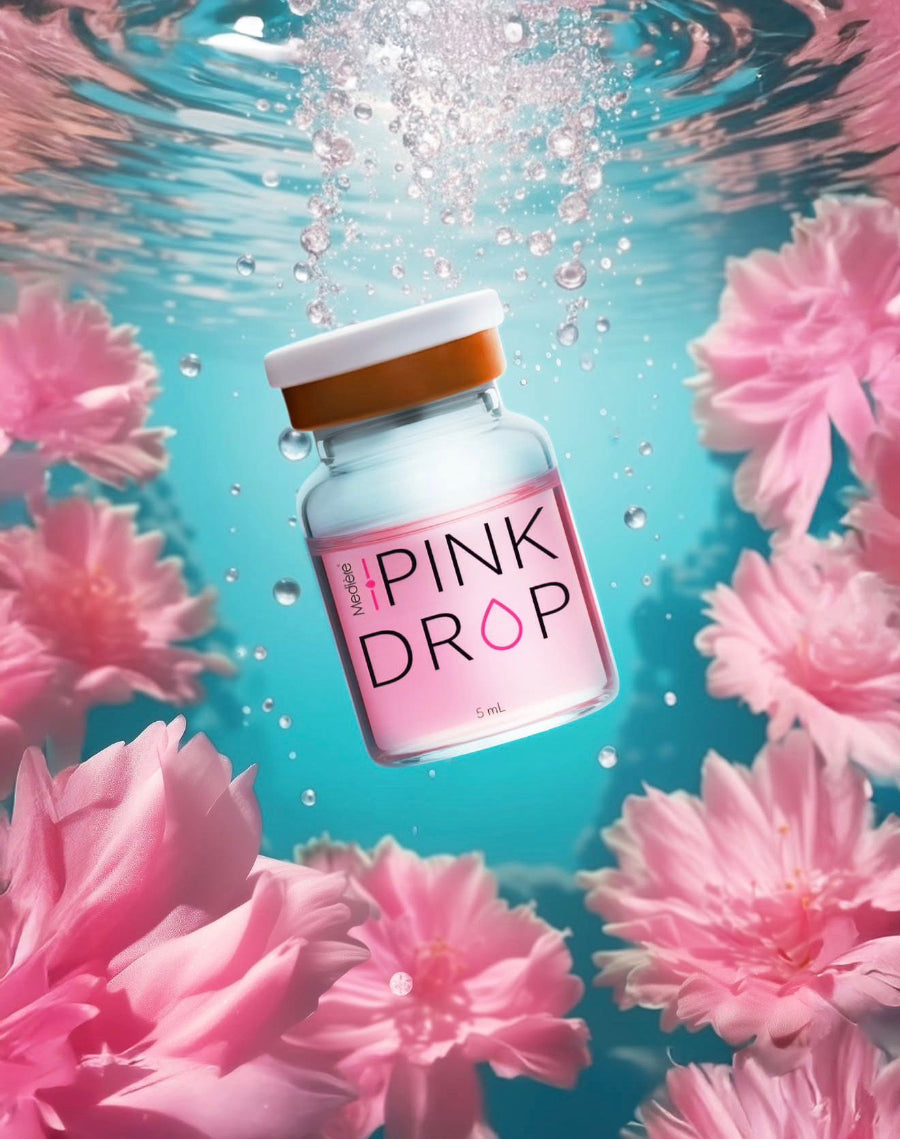 Pink Drop product in a bottle surrounded by pink flowers underwater