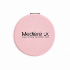 A round pink compact mirror with black text logo