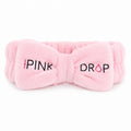 Pink bow-shaped headband with 'Pink Drop' text on a white background