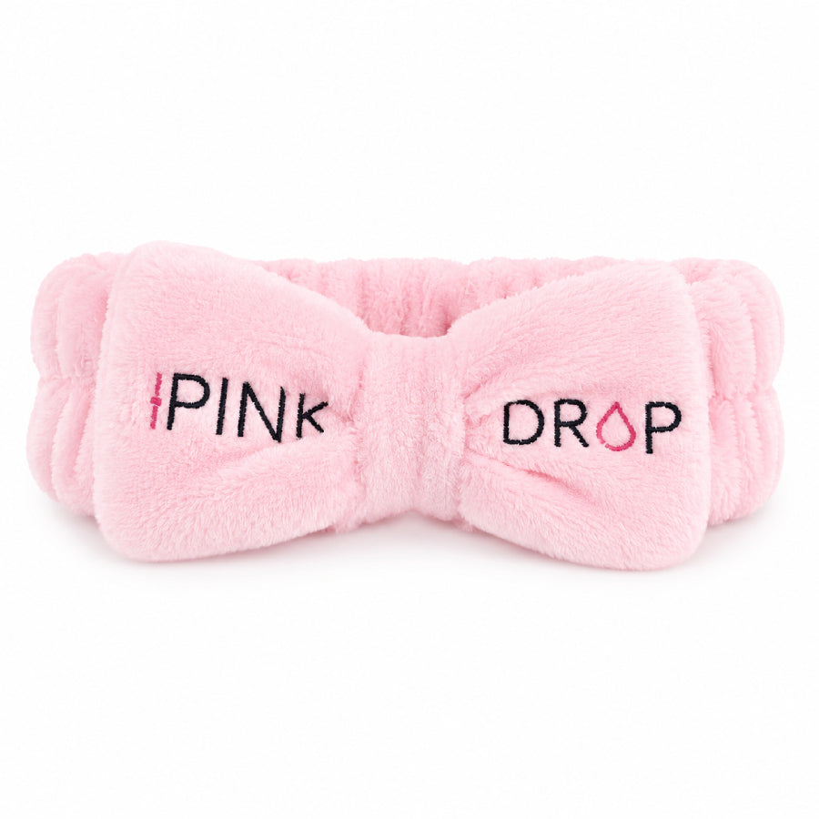 Pink bow-shaped headband with 'Pink Drop' text on a white background